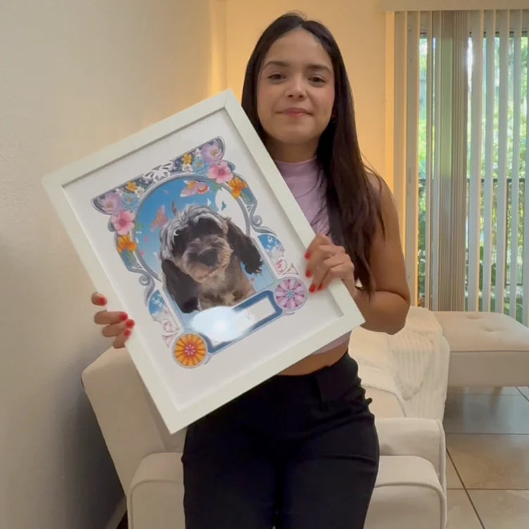 Woman holding a framed picture of a dog with decorative elements indoors.
